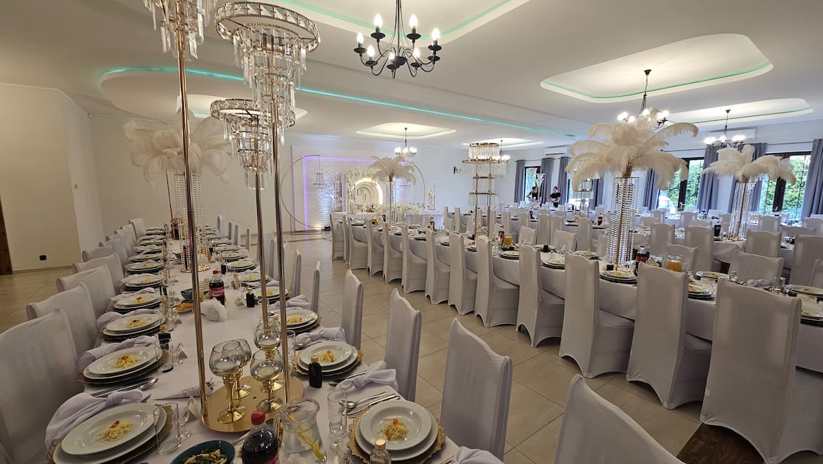 Dekoracja sali weselnej w stylu glamour — kryształowe żyrandole i strusie pióra